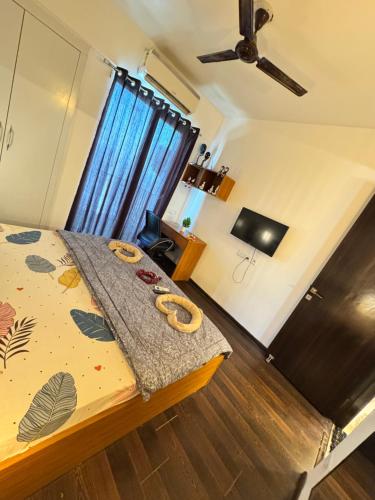 a bedroom with a bed and a ceiling fan at Harmony Heights By Royal Rooms in Noida
