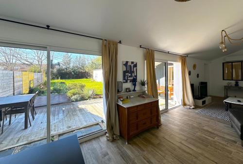 d'un salon avec une grande porte coulissante en verre. dans l'établissement Belle Villa 5 pièces, 3 chambres, à Gujan-Mestras