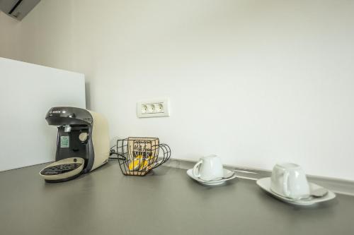a coffee maker and two cups on a counter at Casa Chirila in Giarmata Vii