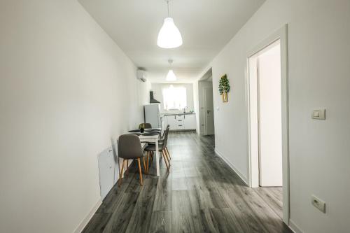 a white kitchen and dining room with a table and chairs at Casa Chirila in Giarmata Vii