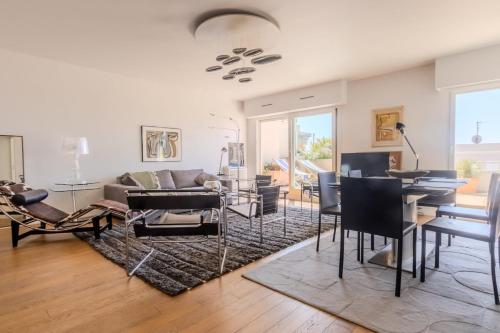 un salon avec un canapé, une table et des chaises dans l'établissement Juan les Pins appartement Rooftop, 2 chambres avec parking, à Antibes