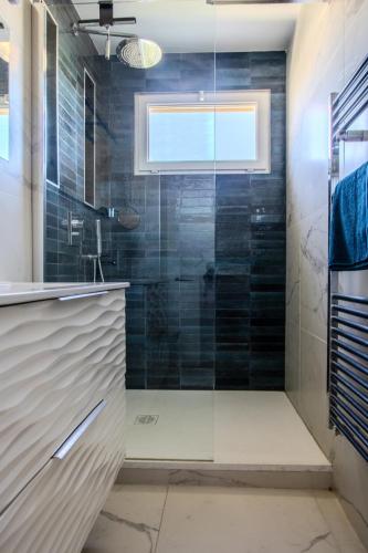 une salle de bain avec une douche avec une porte vitrée dans l'établissement Juan les Pins appartement Rooftop, 2 chambres avec parking, à Antibes