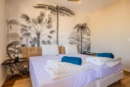 - une chambre avec un lit recouvert de palmiers dans l'établissement Juan les Pins appartement Rooftop, 2 chambres avec parking, à Antibes