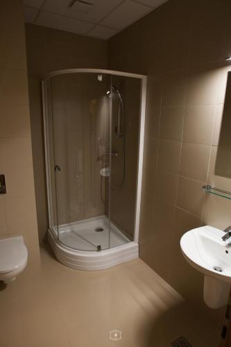 a bathroom with a shower and a toilet and a sink at Grand Central in Carei