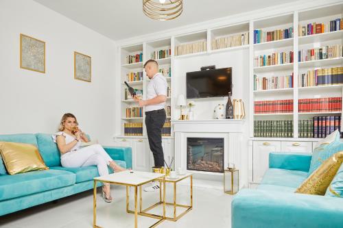 a man standing in a living room with a woman at Szarka DownTown Vendégház in Mád