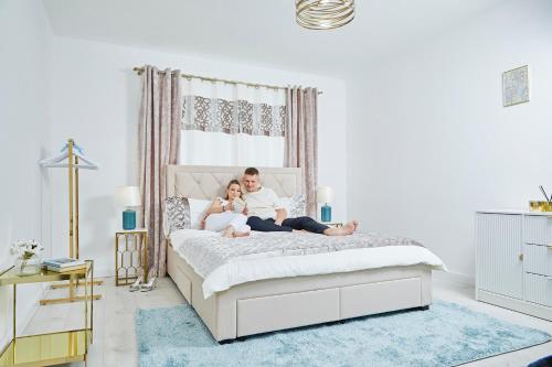 a man and a girl sitting on a bed at Szarka DownTown Vendégház in Mád