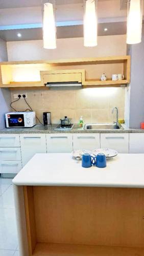a kitchen counter with two blue mugs on it at Shaftesbury Residences Cyberjaya Studio Suites Free Parking in Cyberjaya