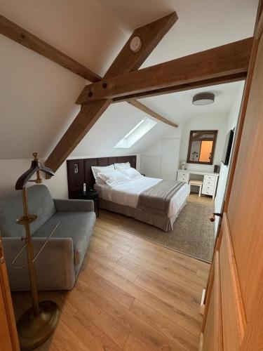 une chambre avec un lit et un canapé dans l'établissement Le cottage Maisonnette dans corps de ferme, à Allainville