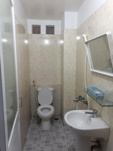 a bathroom with a toilet and a sink and a mirror at Hotel Phương Linh 360 phạm hùng in Ho Chi Minh City