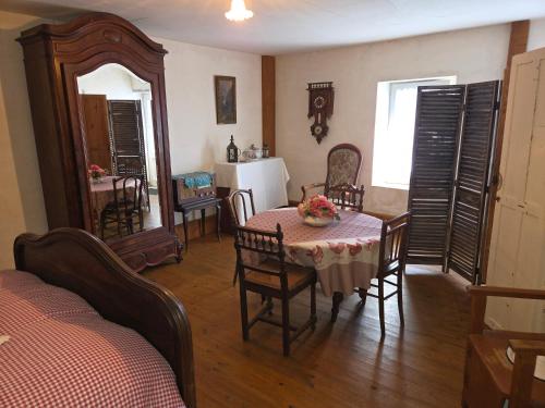 une cuisine et une salle à manger avec une table et des chaises dans l'établissement Chambre insolite années 40 à Omaha Beach pour la nuit du Jour J la plus longue, à Saint-Laurent-sur-Mer