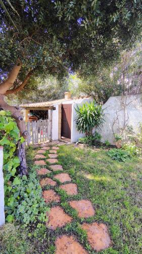 a stone path leading to a garage in a yard at In front of the beach - La terrazza sul mare in Flumini di Quartu