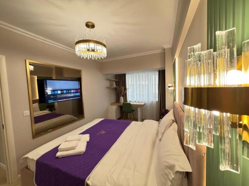 a bedroom with a large bed and a tv at Luxury Evergreen Towers by Glam Apartments in Iaşi