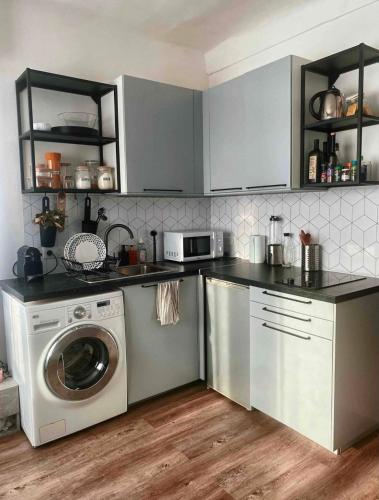 une cuisine avec un lave-linge et un micro-ondes dans l'établissement Nice centre studio rénové avec emplacement central, à Nice