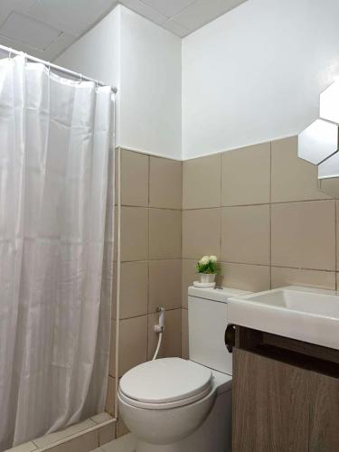 a white bathroom with a toilet and a sink at Bismillah - My Vacation Home in Baguio