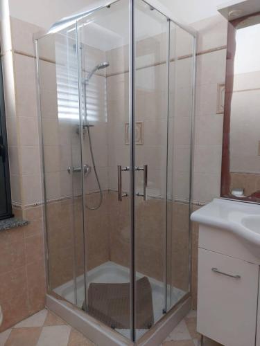 a shower with a glass door in a bathroom at 1Appartamento sulla spiaggia in Spadafora