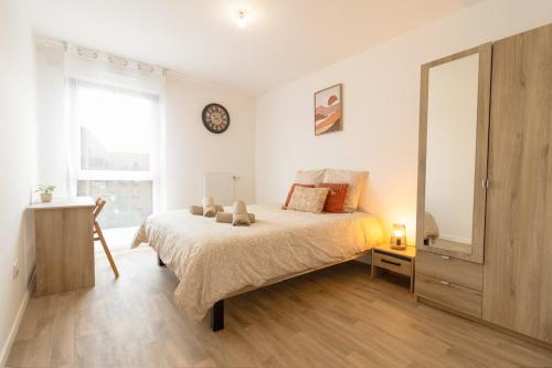 une chambre avec un lit et une horloge au mur dans l'établissement Cocon Paris Stade de France, à Pierrefitte-sur-Seine