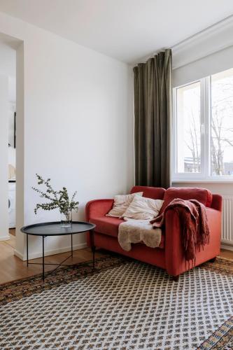 a living room with a red couch and a table at Apartment for friends & families in Tallinn