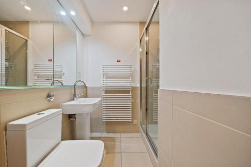 a bathroom with a toilet and a sink and a shower at Spitalfields Sanctuary 2 Bed 2 Bath 100sqm Aprt in London