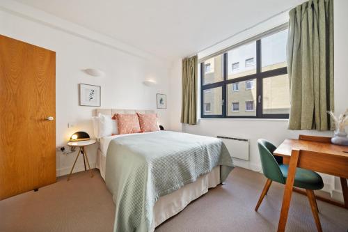 a bedroom with a bed and a desk and a window at Spitalfields Sanctuary 2 Bed 2 Bath 100sqm Aprt in London