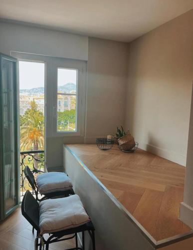une cuisine avec un comptoir avec deux chaises et une fenêtre dans l'établissement Nice vieille ville appartement design, proche de tout, à Nice