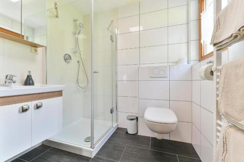 a bathroom with a shower and a toilet and a sink at Pension Seeberger in Wald am Arlberg