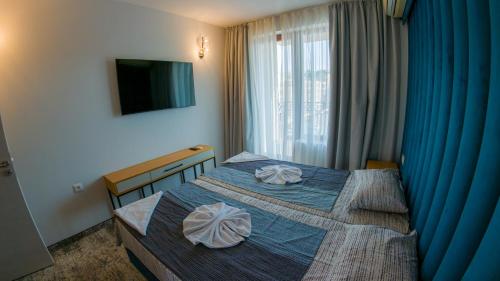 ein Hotelzimmer mit einem Bett mit zwei Kissen darauf in der Unterkunft GoldenSands Apartments in Goldstrand