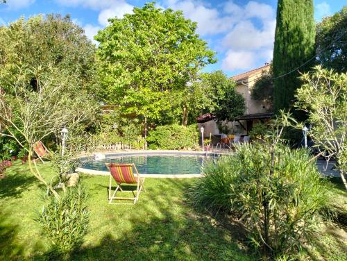 une cour avec une piscine entourée d'une chaise et d'arbres dans l'établissement Petit Mazet Fruits rouges, à Eyragues