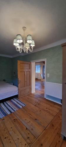 an empty room with a bed and a chandelier at Appartements Brigitte in Stadl an der Mur