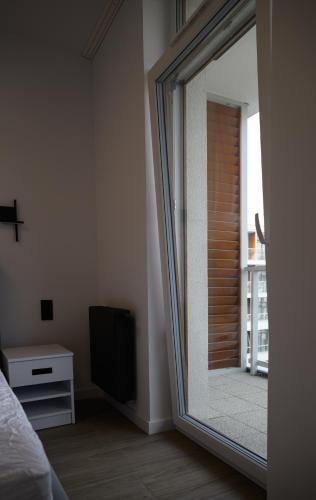 a mirror in a bedroom with a bed and a television at TuWypoczywam - Apartament 58 1C Sianożęty z klimatyzacja i miejscem na dachu in Sianozety