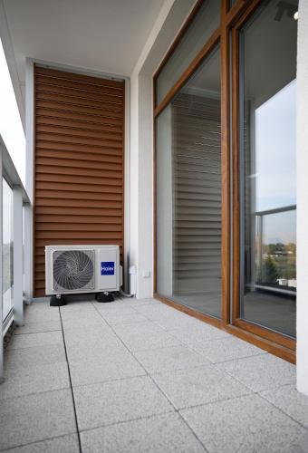 a heater sitting on a patio outside of a house at TuWypoczywam - Apartament 58 1C Sianożęty z klimatyzacja i miejscem na dachu in Sianozety
