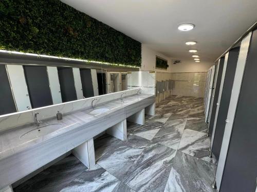 eine Reihe von Waschbecken in einer öffentlichen Toilette in der Unterkunft Sax Camping Costinesti in Costinești