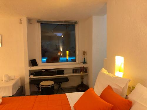 a bedroom with a bed and a window with a television at Small Pool Villa at Marathon Greece in Marathón