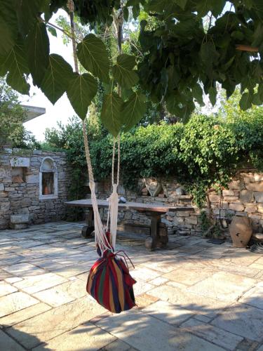 a picnic bench with a bag hanging from a tree at Small Pool Villa at Marathon Greece in Marathón