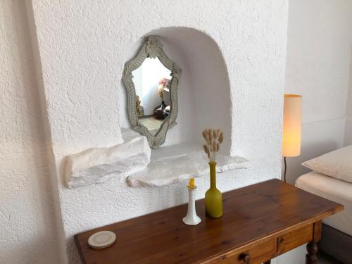 a mirror on a wall next to a wooden table at Small Pool Villa at Marathon Greece in Marathón