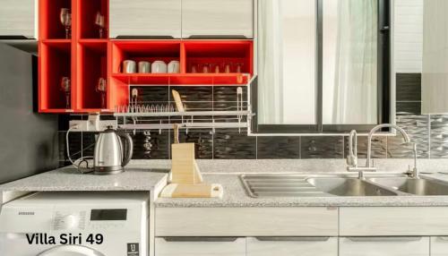 a kitchen with red cabinets and a sink at Villa Siri 49 Luxury 4 BR Chiang Mai in Chiang Mai