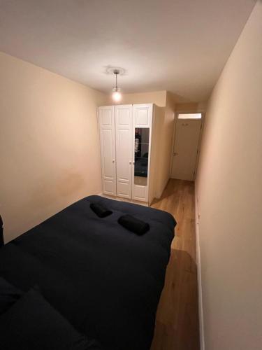 a small bedroom with a black bed and a kitchen at Superb Double Room near the Spire - 2 in Dublin