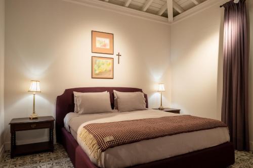 a bedroom with a large bed with two lamps at Vinte-Quinta da Boavista in Ponte de Lima