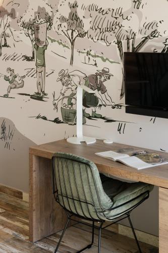 a desk with a chair in front of a wall with a mural at Vinte-Quinta da Boavista in Ponte de Lima