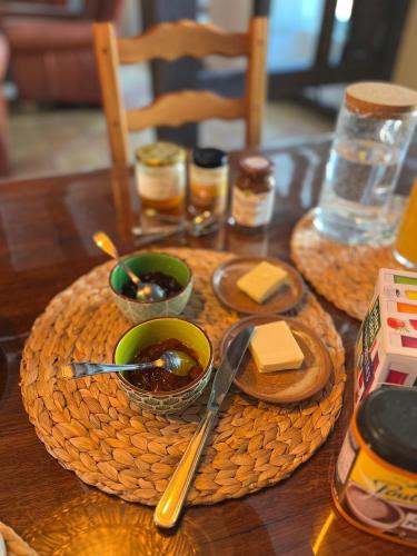 a wooden table with two bowls of soup and butter at Chambres d'hôtes "Là Je Ris" in Lagery