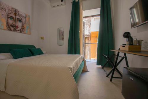 a bedroom with a bed and a window with green curtains at Massimo Rooms and suite in Palermo