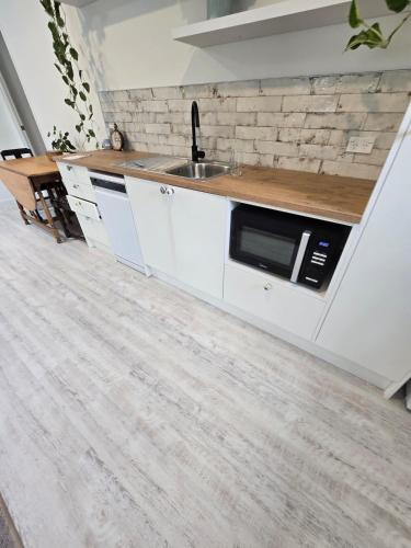 a kitchen with a sink and a microwave at Bethlehem Home, plus Self Contained Apartment in Tauranga
