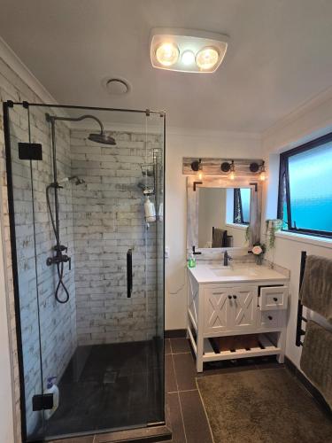 a bathroom with a shower and a sink at Bethlehem Home, plus Self Contained Apartment in Tauranga