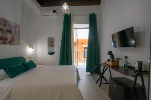a bedroom with a bed with green curtains and a window at Massimo Rooms and suite in Palermo