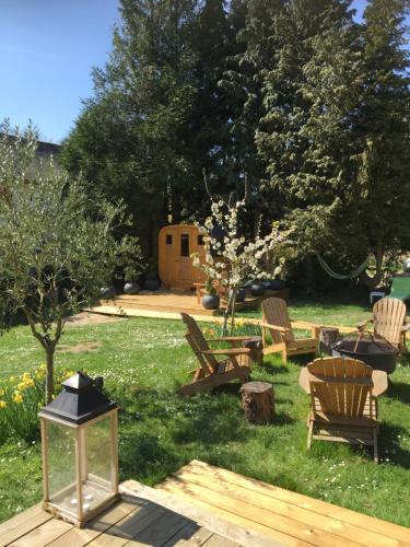 a yard with a group of chairs and a table at Villa des glycines et Spa in Cempuis
