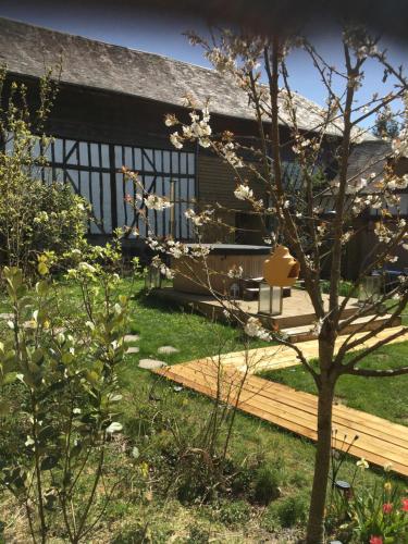 a house with a wooden deck and a tree at Villa des glycines et Spa in Cempuis