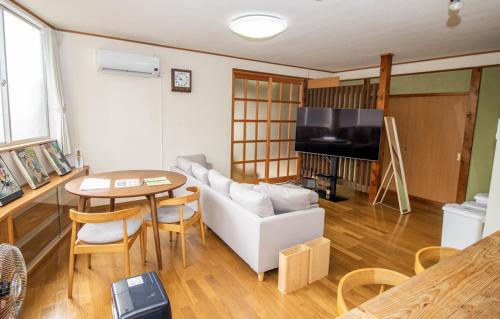 a living room with a couch and a table at GLOCE sado ベースキャンプ 松ヶ崎 ワンちゃんと泊まれます in Sado