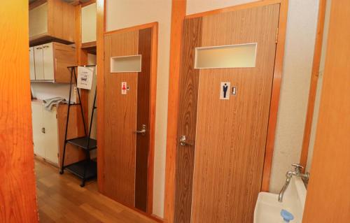 a hallway with two wooden doors in a room at GLOCE sado ベースキャンプ 松ヶ崎 ワンちゃんと泊まれます in Sado