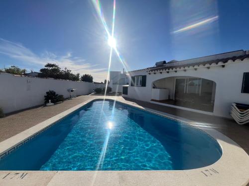 a villa with a swimming pool in front of a house at Villa Coral in Cala en Porter