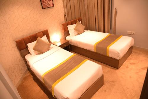 two beds in a hotel room with two beds sidx sidx sidx at Dahlia Venti Hotel Apartment- formerly days inn by dahlia - Al Jahra in Jahra