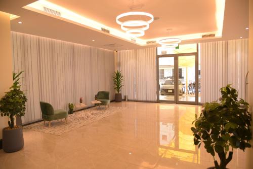 a lobby with chairs and plants in a building at Dahlia Venti Hotel Apartment- formerly days inn by dahlia - Al Jahra in Jahra